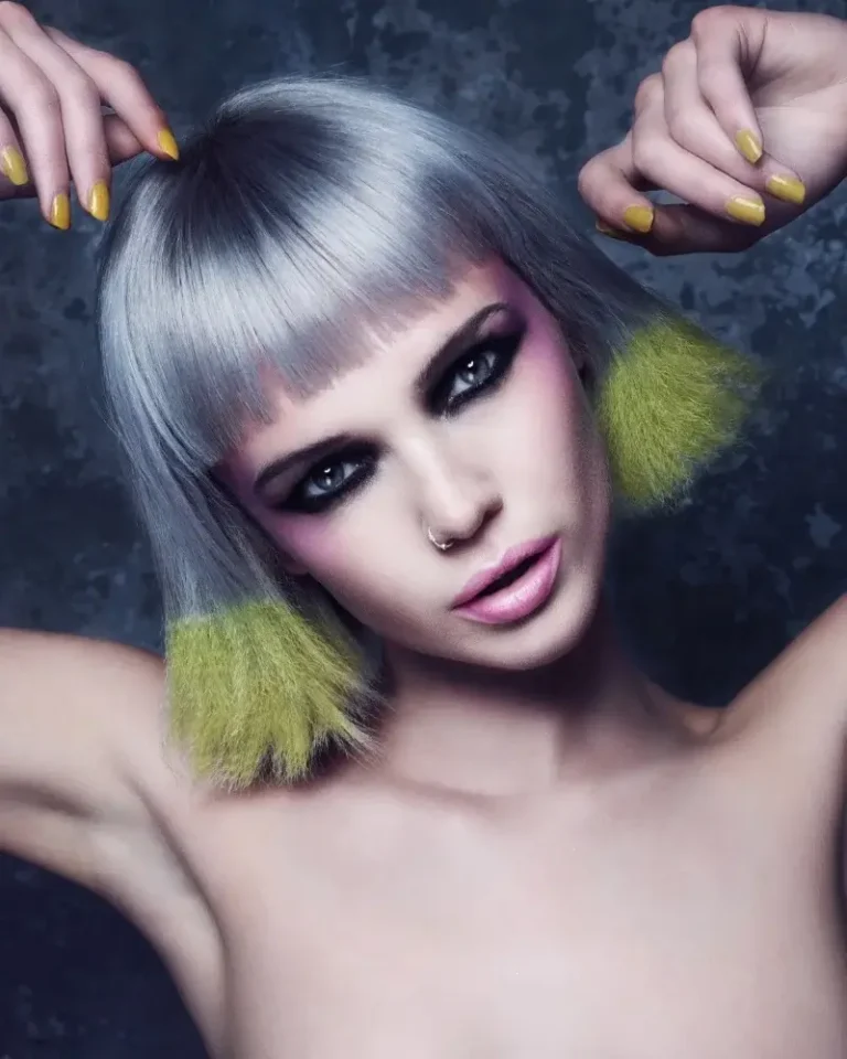 Model showcasing a sleek silver-grey bob with straight micro-bangs and bright neon yellow ends