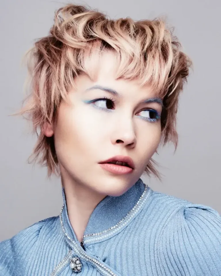 Model with straight ash-brown hair featuring framed cheek-length layers and blunt, textured bangs