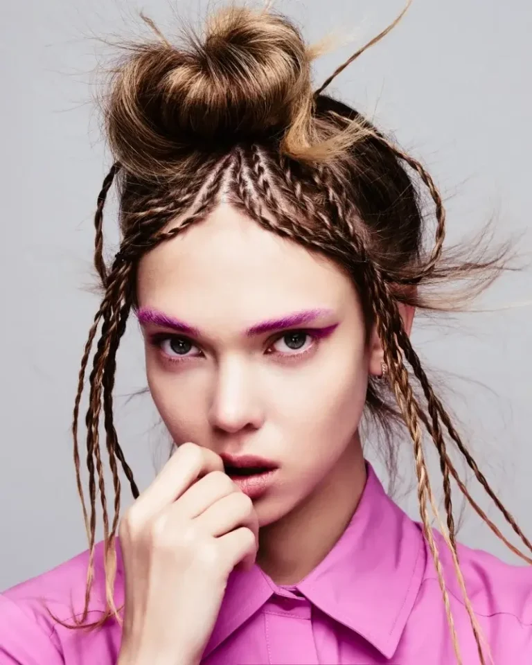 Model wearing a pink button-down shirt with braided micro-dreadlocks and styled accent tendrils framing her face