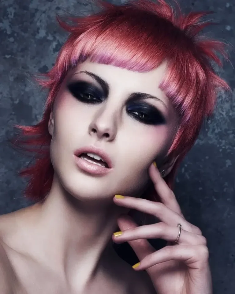 Model with a textured magenta-pink mullet haircut featuring short straight fringe and spiky sides