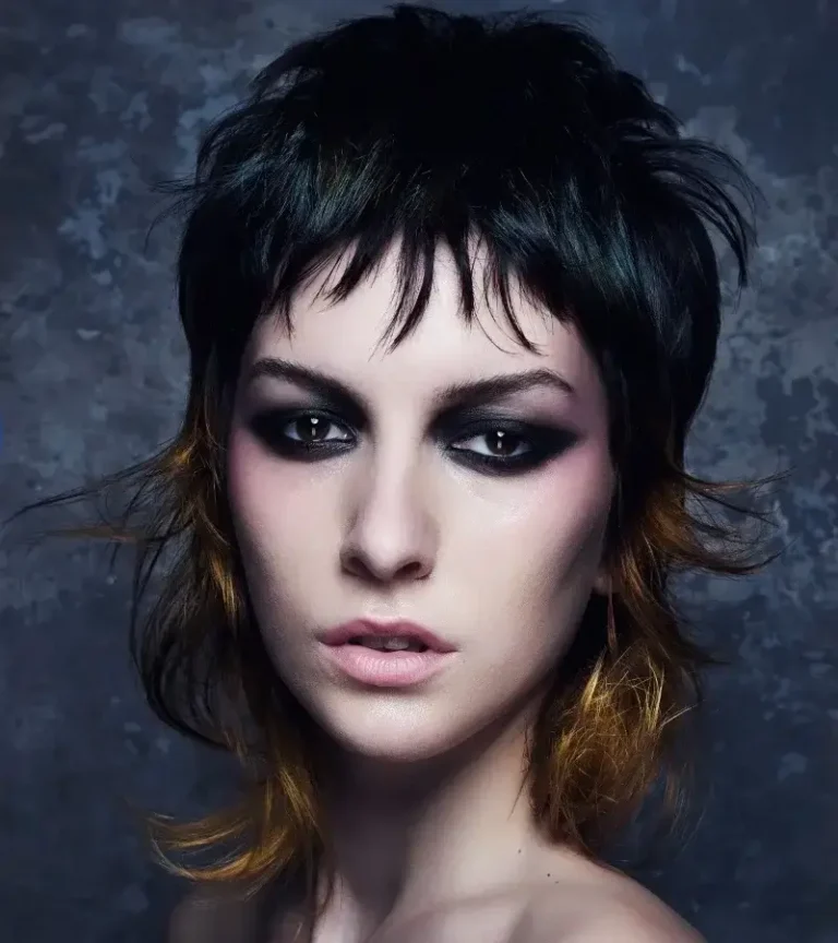 Model with a dark shag cut featuring short piecy bangs and warm amber tips 2