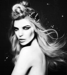 Black and white portrait of a woman with long, glamorous beachy waves and a structured, twisted top knot accented with hair pins