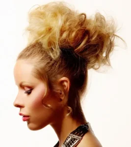 Profile shot of model with a voluminous, messy blonde topknot updo styled for Joseph Ferraro Hair BHA 2010