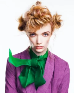 Blonde model with playful textured space buns and green neck scarf styled for Joseph Ferraro Hair Evocative collection